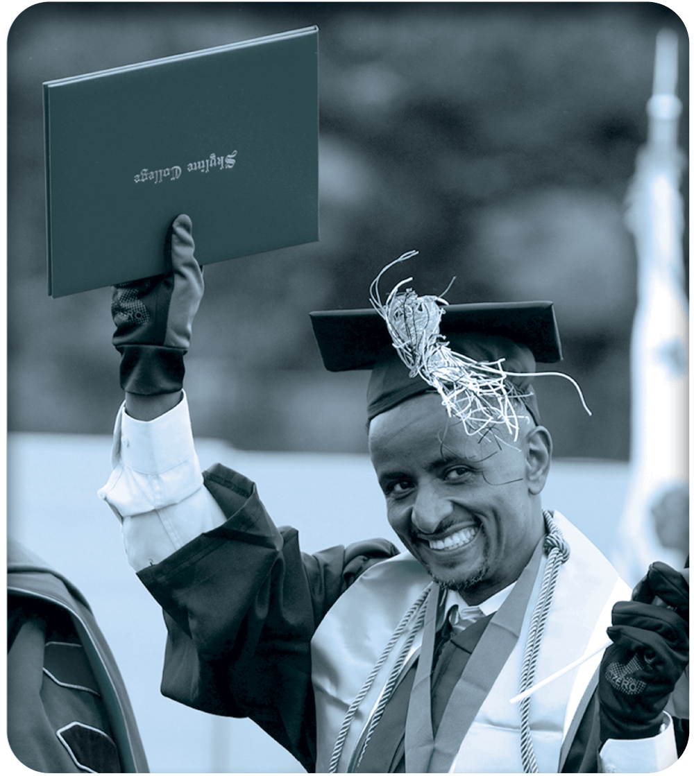 A Skyline graduate holds up his diploma as he crosses the stage