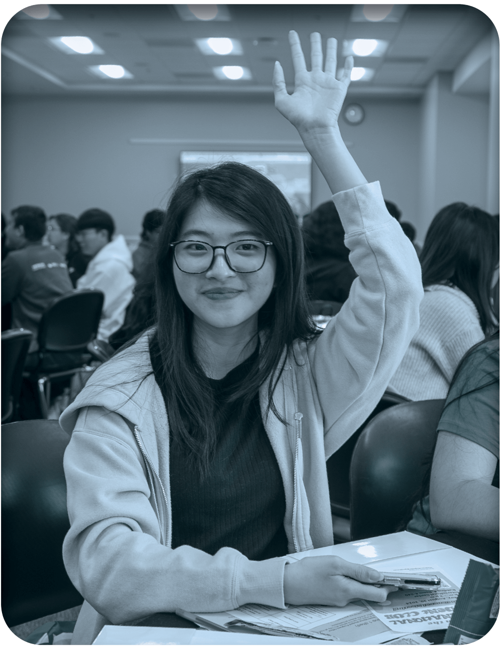 student smiling and raising hand