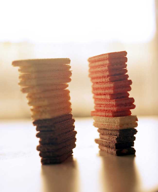 two towers of stacked white, brown, and pink rectangular cookies