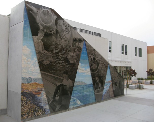 full view of art on a triangular wall of an external staircase, featuring etched steel and ceramic tile of the coast