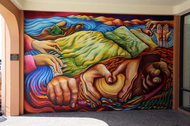 Painted mural of hands holding the earth and water in a warmly organic, colorful style.