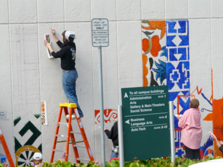 two artists sketch out the beginning of the mural on the wall