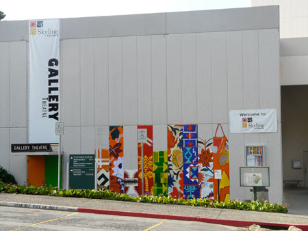 a far-away shot of the in-progress mural and banner over the art gallery door