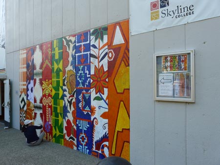 an artist puts final touches on the bottom of the mural