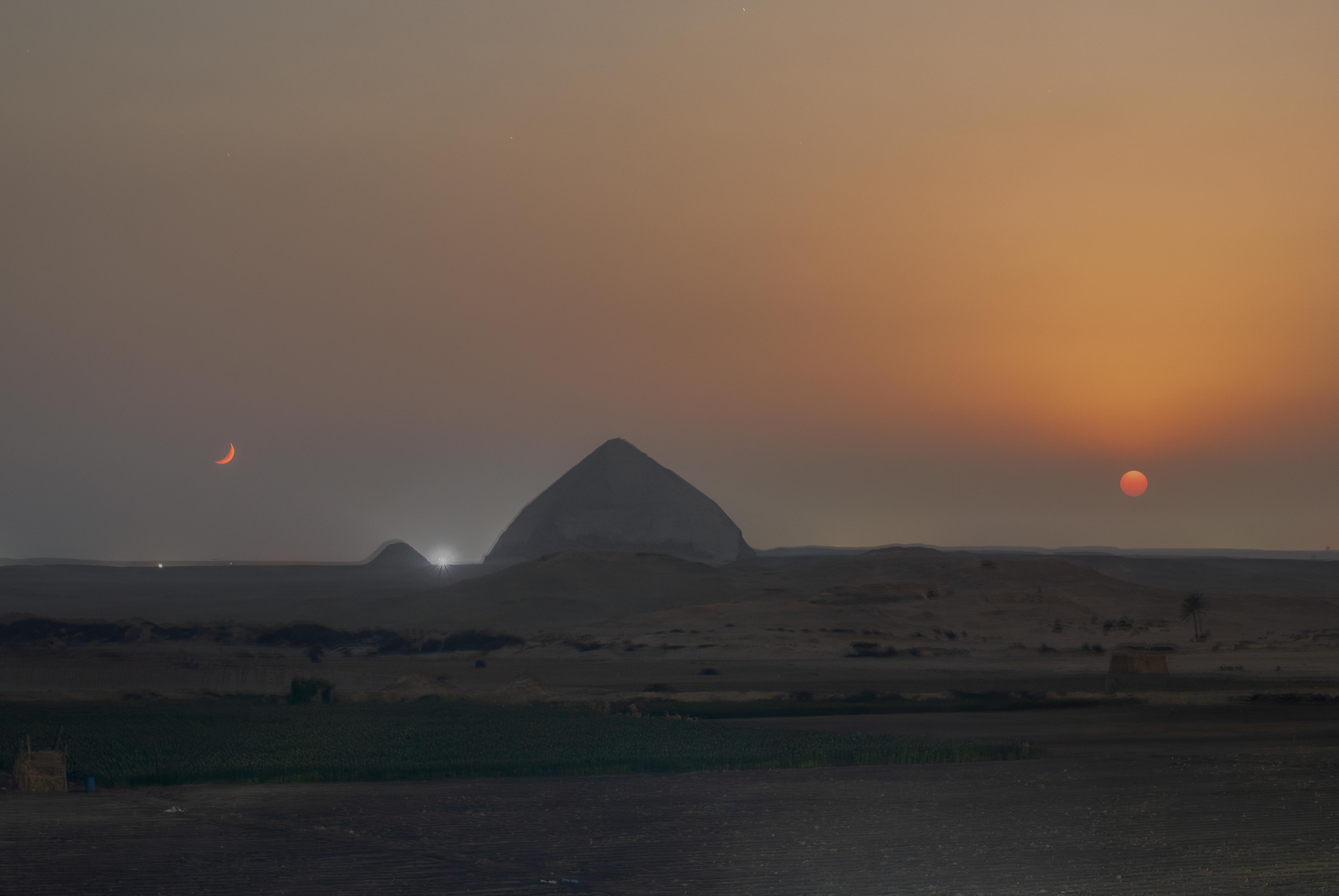 Pyramid with a moon and sun on either side