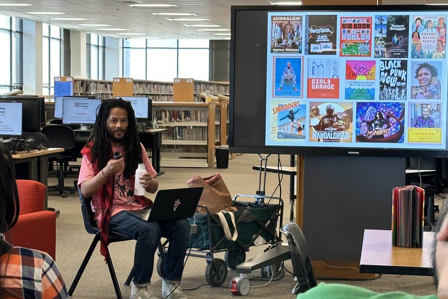 Rock the School Bells activity: person gives a lecture about various relevant books