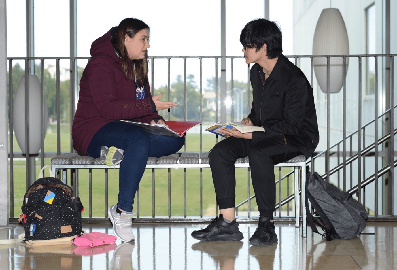 two students on a bench talking