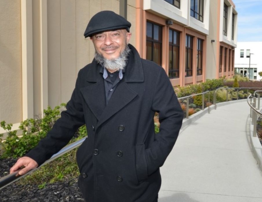Older student walks up through campus toward the quad