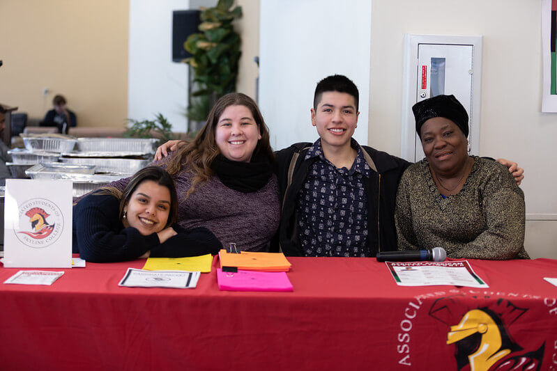 A group of 4 Skyline College students at a table during an event