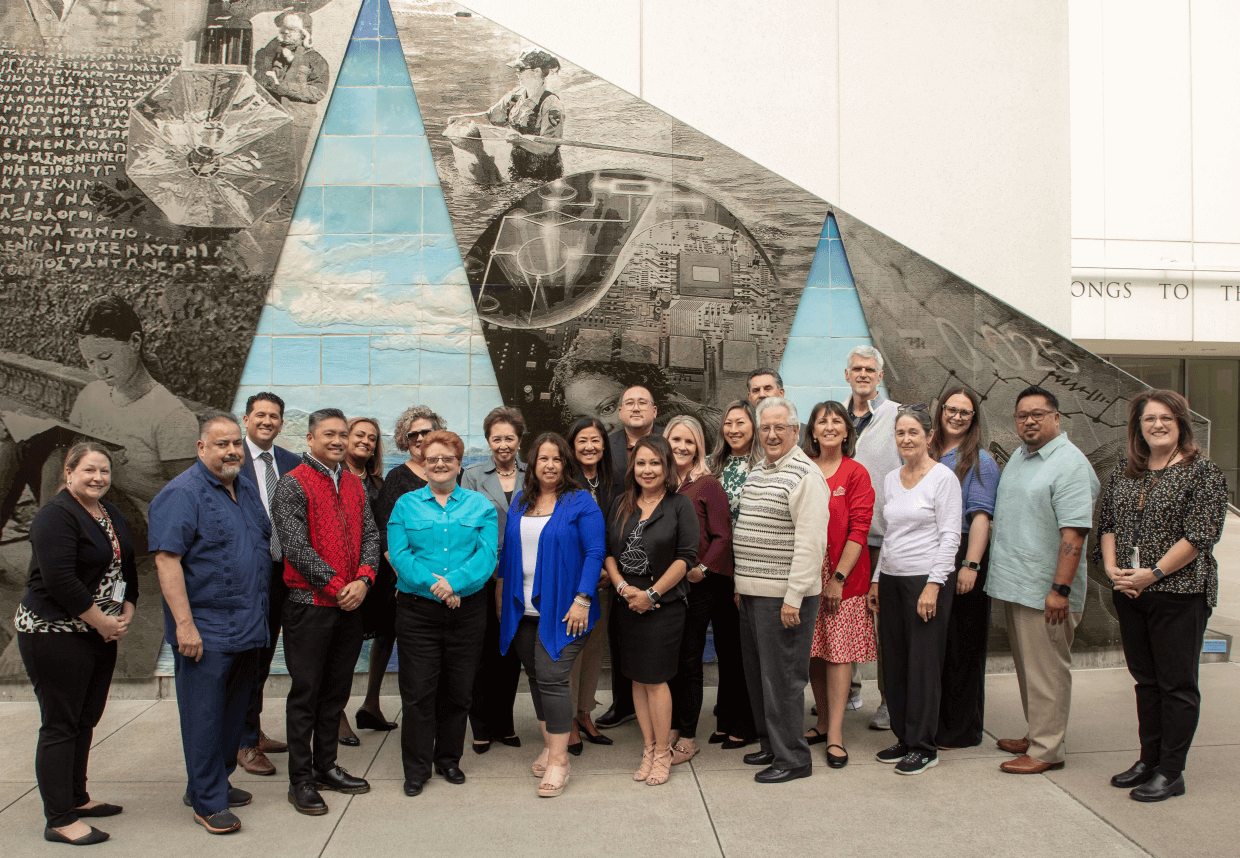 president's council members stand in front of an outdoor mural on Skyline campus