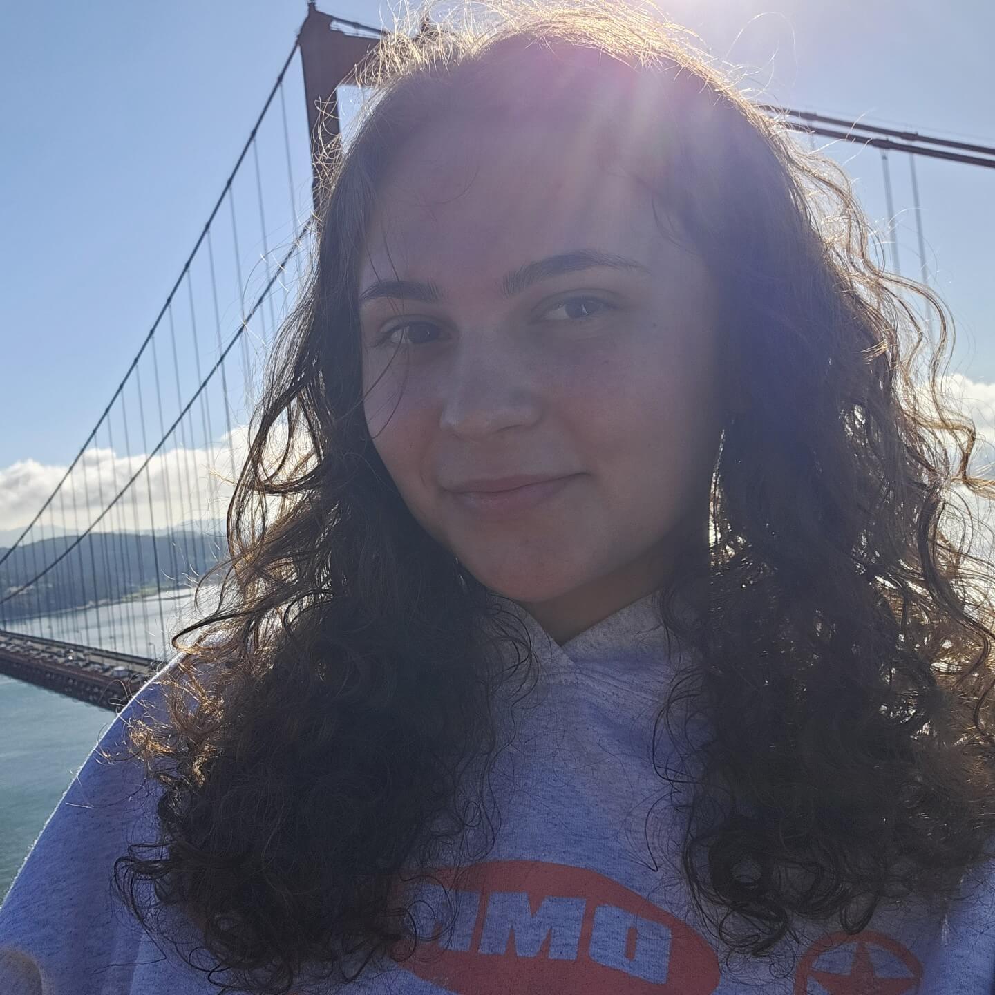 Casual selfie of Mia Sideris in a gray sweatshirt in front of the Golden Gate Bridge